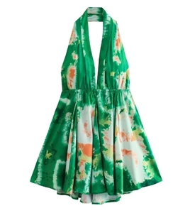 Dettaglio di un abito allacciato al collo tie-dye verde con scollo a V e vita alta definita