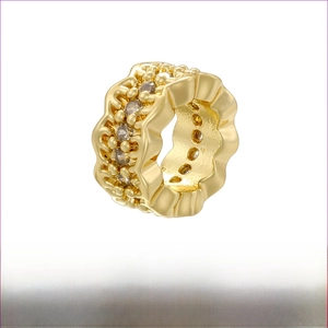 Detail view of wave-shaped gold brass earring with inlaid crystals and precise dimensions