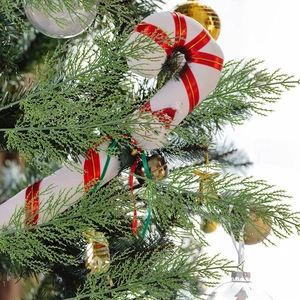 Bastoncino di zucchero in peluche con nastro rosso e campanellini per l'albero