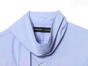 Close-up of the light blue shirt collar and size tag showing premium cotton texture
