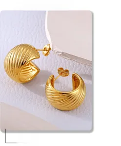 Close-up of 18k gold plated stainless steel C-shape twisted hoop earrings on stone