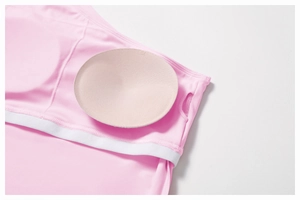 Detail view of pink yoga vest with removable XS round chest pad and white elastic trim