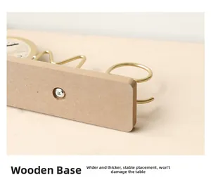Detail view of thickened wooden base and golden metal frame on minimalist table clock