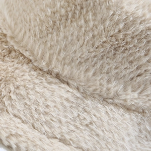 Détail de la texture en peluche beige doux montrant l'épaisseur de la fausse fourrure