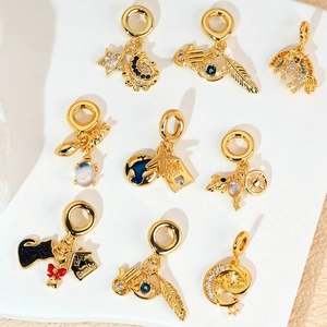 Golden travel collection charms with zircon including airplane, passport and celestial motifs