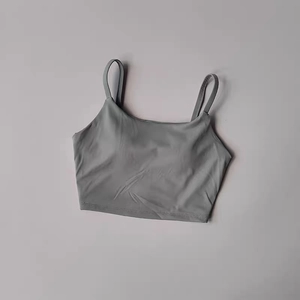 Détail macro du débardeur de sport gris-vert respirant avec doubles fines bretelles