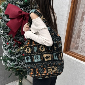 Detailed close-up of a large ethnic plush tote bag with geometric patterns worn on shoulder