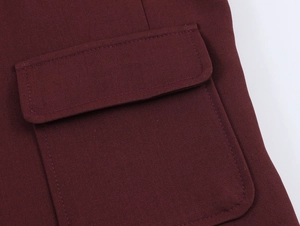 Detail view of the wine red tweed jacket showing flap pocket texture and metal button