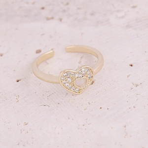 Macro shot of gold heart ring with micro-paved zircons on a textured stone surface