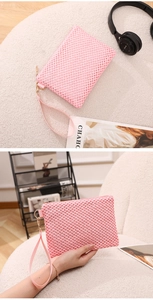 Detail of pink woven mesh handbag with gold zipper and stylish wrist strap accessory