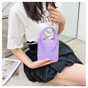 Detail of purple crocodile texture crossbody bag with elegant golden chain strap