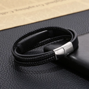 Detail of men's multilayer black braided leather bracelet with silver magnetic metal clasp