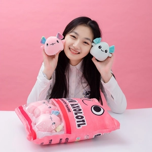 Plush pink axolotl snack bag toy set with multiple mini dolls held by a model
