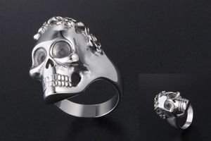Detailed close-up of a silver skull ring in punk style with aged metal finish