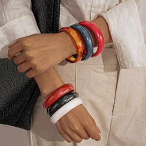 Vintage chunky resin bangles in multiple colors worn by a model in a minimalist style