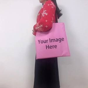 Detail view of pink polyester tote bag with large capacity and black fabric strap on model