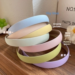 Set of 6 minimalist pastel faux leather headbands in macro view on wooden background