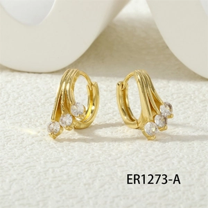 Close-up of golden hoop earrings featuring three sparkling clear zircon gemstones