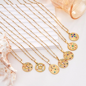 Colliers en acier inoxydable doré avec pendentifs boussole et cœur sur blanc