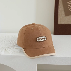 Detailed close-up of brown kids baseball cap with contrast piping and puppy embroidery