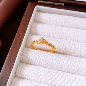 Détail de la bague vintage dorée avec pierre étoile rose et anneau filigrané poli