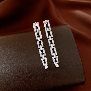 Dettaglio degli orecchini geometrici in argento con design a catena in zirconi