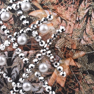 Macro shot of leopard print fabric with white pearls and sparkling silver rhinestones