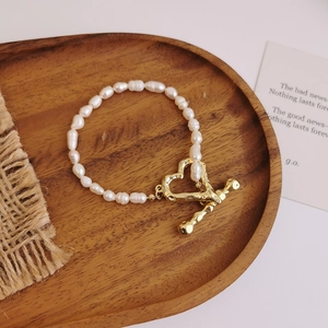 Detail of freshwater pearls bracelet with a golden heart-shaped toggle clasp