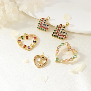 Golden heart pendants with colorful zircon inlay and mosaic cross design on white cloth