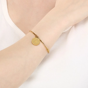 Adjustable gold stainless steel bangle featuring a religious cross pendant charm for women