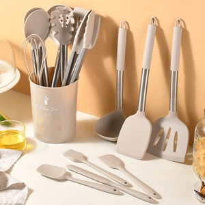 14-piece beige silicone cooking utensil set with stainless steel handles and storage bucket