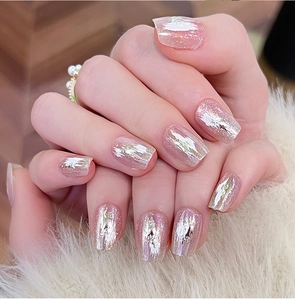 Détail d'ongles roses œil de chat avec feuille métallique argentée et finition pailletée