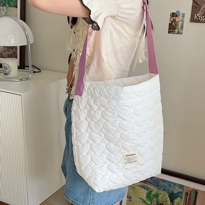 White heart-quilted tote bag with contrast purple strap and spacious design