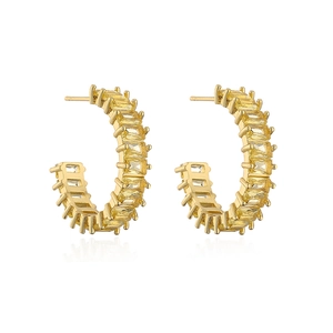 Detail of 18K gold plated C-shaped earrings set with yellow rectangular zircons on white