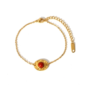 Détail d'une pierre rouge dans un bracelet en acier inoxydable martelé plaqué or 18K