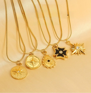 Detail of five gold stainless steel tarot necklaces featuring sunburst and star pendants