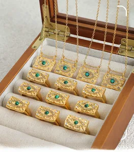 Macro view of evil eye square pendants and rings with green malachite on wood box