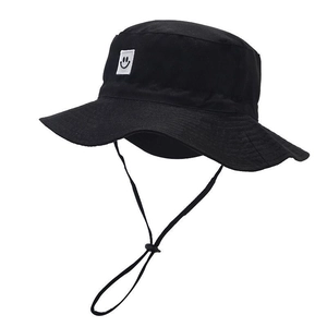 Detail of kids black sun hat featuring a smile patch and adjustable chin strap
