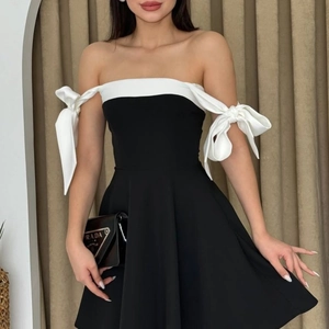 Detail view of off-the-shoulder neckline with elegant bow ties and contrasting black fabric