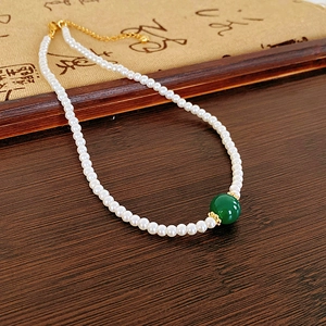 Détail du collier de perles plaqué or 18 carats avec une perle de jade vert rond