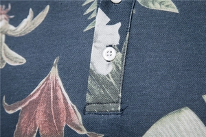 Close-up of floral print polo shirt featuring piqué fabric texture and button detail