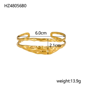 Detail view of gold open bangle with irregular texture and dimension specifications