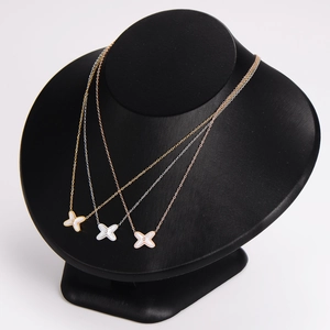 Elegant gold, silver, and rose gold X-shaped cross necklaces with white shell and diamonds