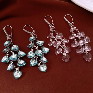 Detailed view of long heart-shaped crystal tassel earrings in blue and pink finishes