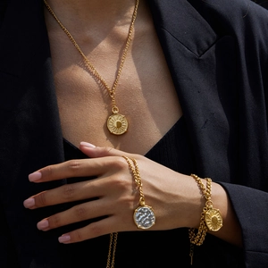 Close-up of vintage sun coin necklace and bracelet set in gold-plated stainless steel