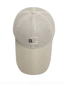 Vue de dessus d'une casquette en maille beige avec broderie ag pour l'été respirante