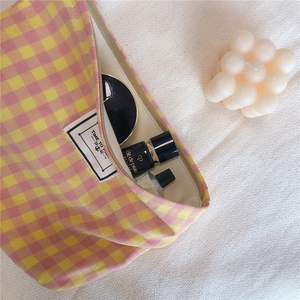 Internal view of plaid cotton makeup bag with cosmetics showing its large storage capacity