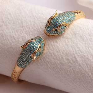 Luxury gold-plated bangle featuring dual leopard heads with blue turquoise pavé stones