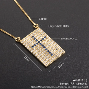 Macro shot of 18k gold plated copper cross necklace with blue cubic zirconia and detailed specs