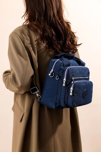 Vue arrière d'un mannequin portant un sac à dos en nylon bleu marine à fermetures éclair
